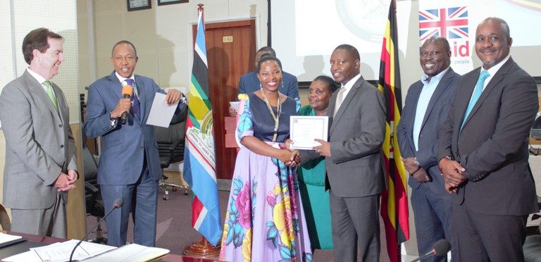 Bahati hands over certificate to GEB national trainer at Ministry of Finance on Friday