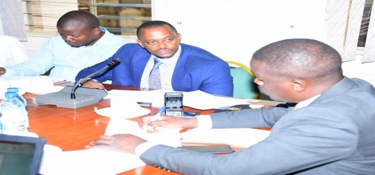 Hon Bukenya(R) listens to Kilimi (in blue jacket) make his submission