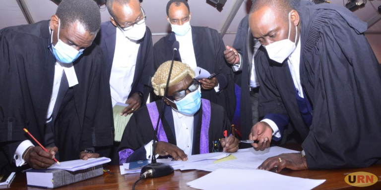 Kyagulanyi's lawyer Sseggona talking to the head of the bar Attorney General William Byaruhanga as other advocates look on.