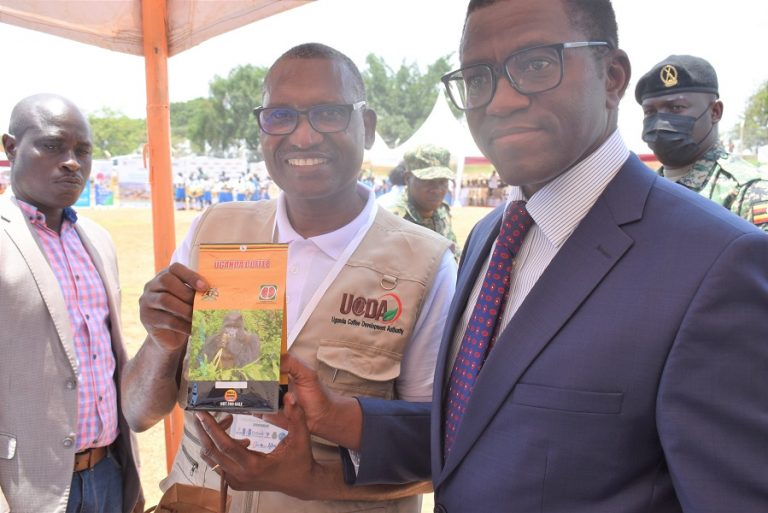 UCDA MD Emmanuel Iyamulemye hands over a Robusta coffee handbook to Buganda Kingdom Premier, Charles Peter Mayiga