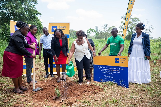 Team From Housing Finance Bank and Gayaza High School plant a tree at the school farm after handing over 120 trees to the school. (1)