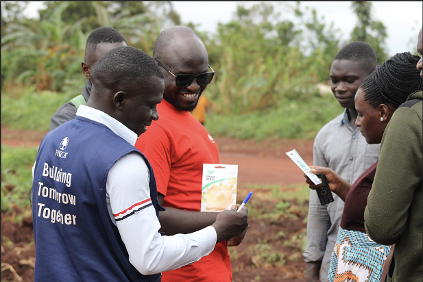 A group of youth and an associate from FINCA discussing financial and business growth.
