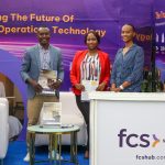 JAFAR AJENA OF FCS SOLUTIONS POSES WITH COLLEAGUE AT THE FCS BOOTH